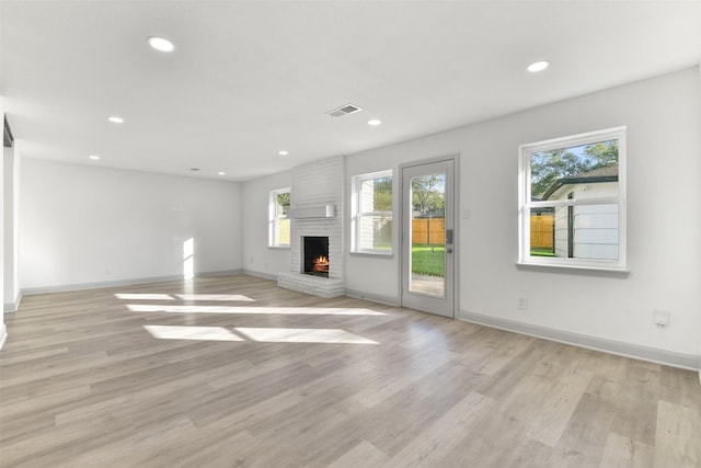 unfurnished living room featuring a fireplace and light hardwood / wood-style flooring