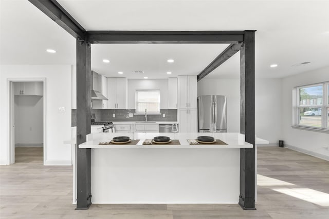 kitchen featuring sink, a wealth of natural light, tasteful backsplash, white cabinetry, and stainless steel appliances