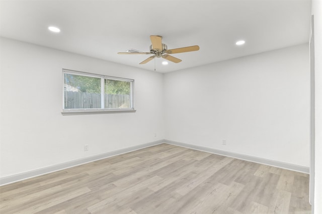 empty room with ceiling fan and light hardwood / wood-style floors