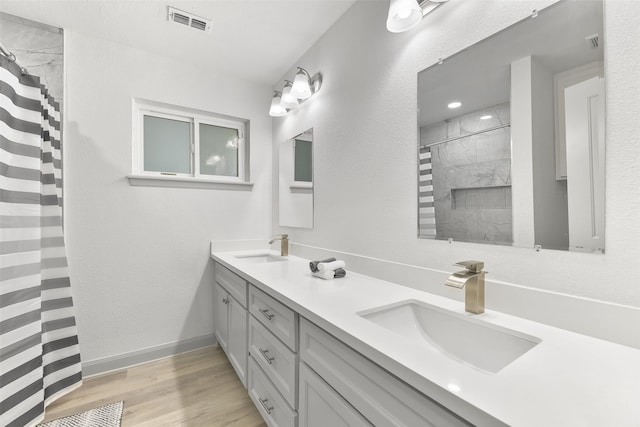 bathroom with hardwood / wood-style floors, vanity, and walk in shower