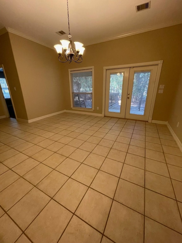 spare room featuring crown molding, light tile patterned flooring, and a notable chandelier