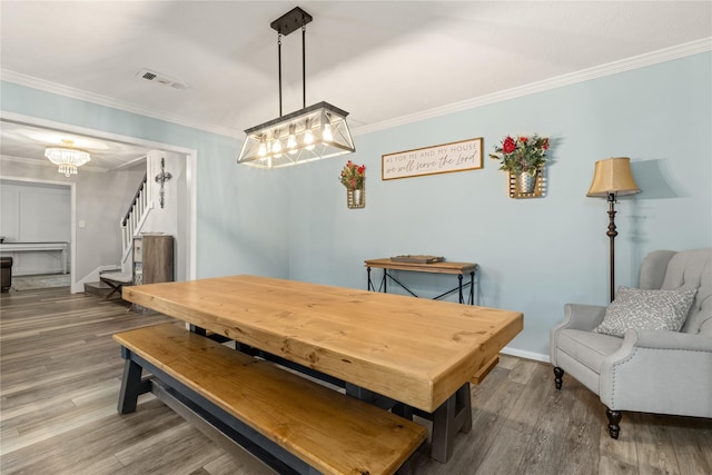 dining room with a chandelier, hardwood / wood-style flooring, and crown molding