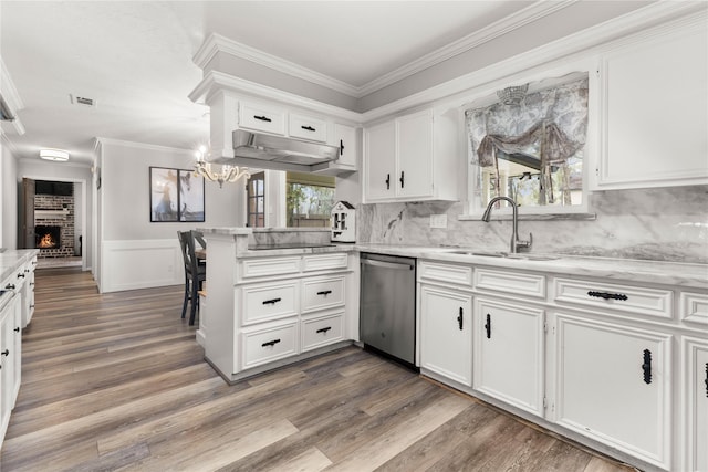 kitchen with stainless steel dishwasher, white cabinetry, kitchen peninsula, and sink