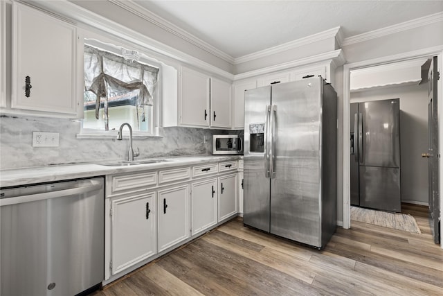 kitchen with decorative backsplash, sink, white cabinetry, and stainless steel appliances