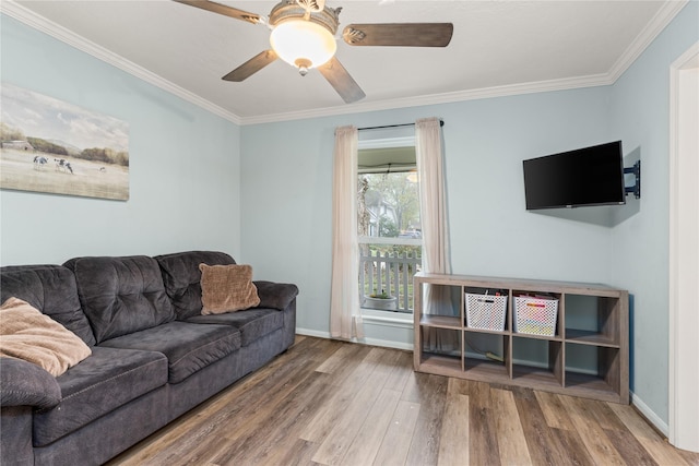 living room with hardwood / wood-style flooring, ceiling fan, and ornamental molding