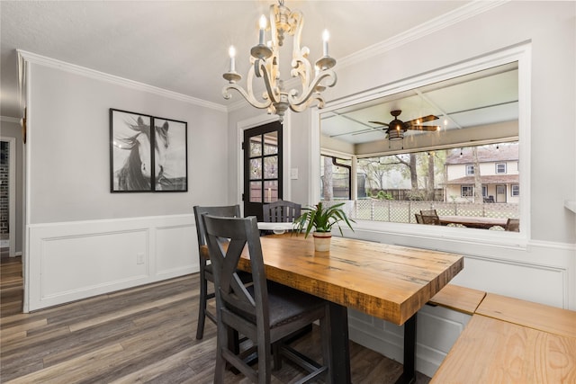 dining space with crown molding, plenty of natural light, dark wood-type flooring, and ceiling fan with notable chandelier