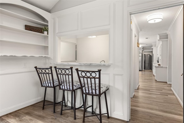 interior space featuring wood-type flooring and crown molding