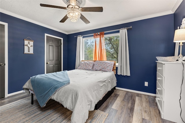 bedroom with ceiling fan, hardwood / wood-style floors, and crown molding