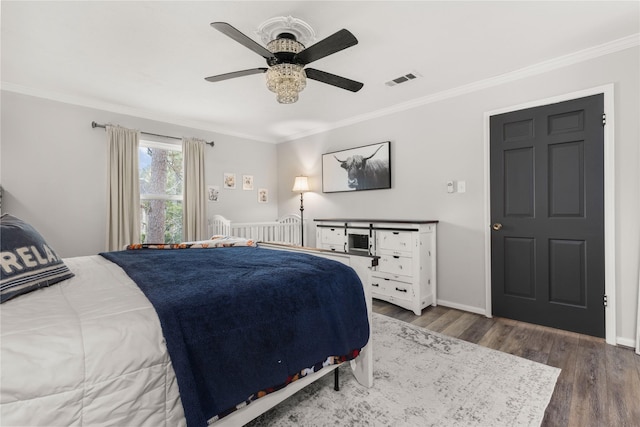 bedroom with ceiling fan, dark hardwood / wood-style floors, and crown molding