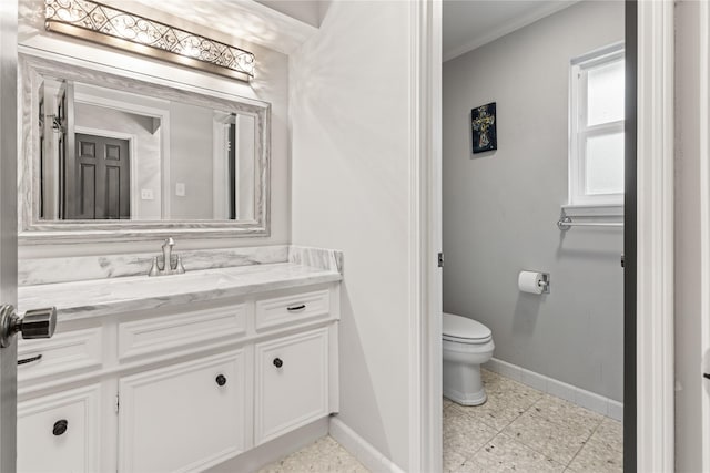 bathroom with toilet, vanity, and ornamental molding