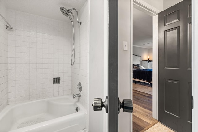 bathroom with hardwood / wood-style floors and tiled shower / bath combo