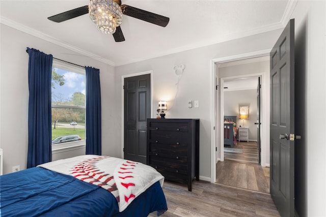 bedroom with hardwood / wood-style floors, ceiling fan, and ornamental molding