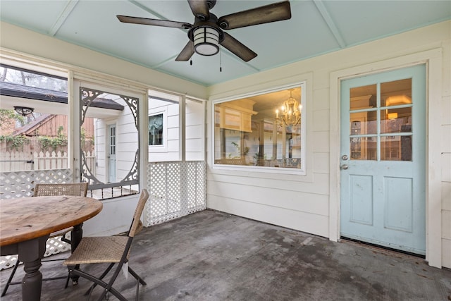 unfurnished sunroom featuring ceiling fan with notable chandelier