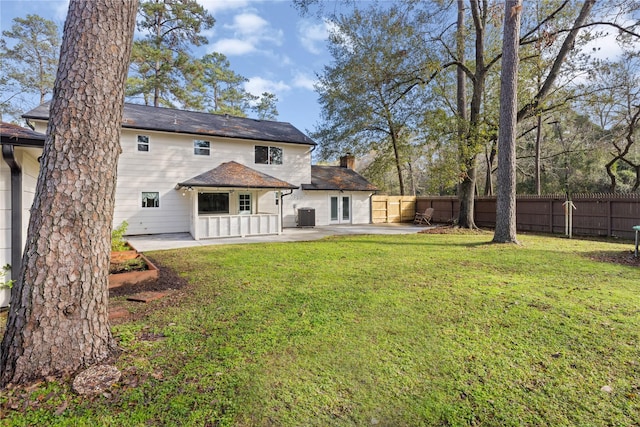 rear view of property with a lawn, central AC, and a patio