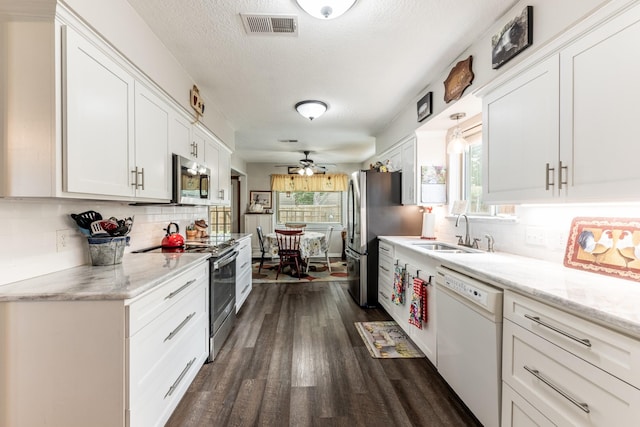 kitchen with white cabinetry, sink, dark wood-type flooring, tasteful backsplash, and appliances with stainless steel finishes