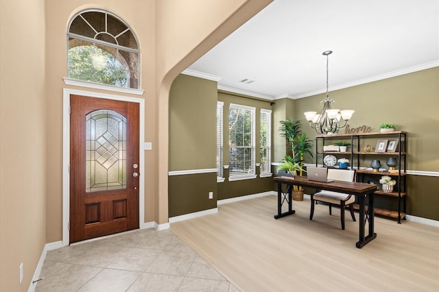 entryway with ornamental molding, light hardwood / wood-style floors, and a notable chandelier