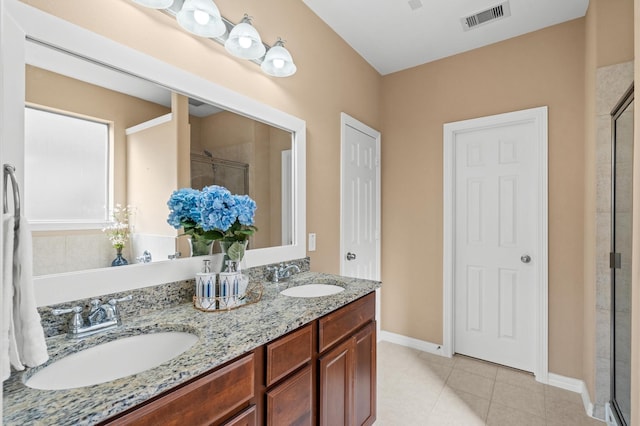 bathroom featuring a shower with door, vanity, and tile patterned floors