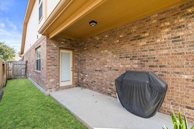 view of exterior entry featuring a patio area and a yard