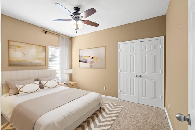 carpeted bedroom with ceiling fan and a closet