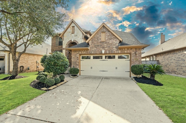 french country inspired facade with a front lawn and a garage