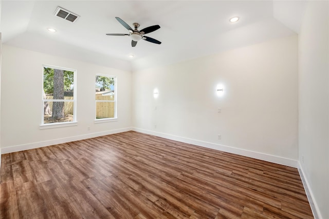 empty room with ceiling fan, lofted ceiling, and dark wood-type flooring