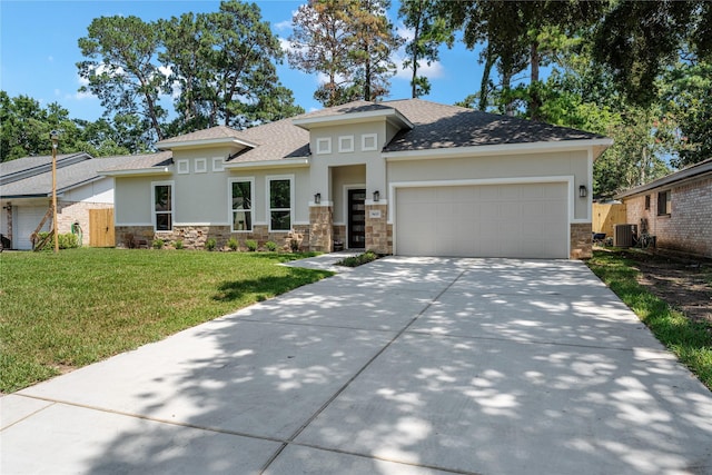 view of front of house with central air condition unit, a front lawn, and a garage