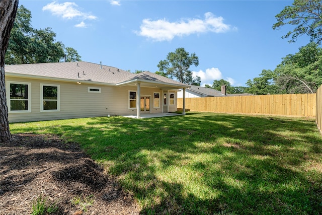 back of house with a patio area and a yard