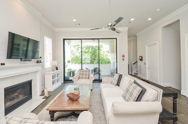 living room featuring a wealth of natural light, ceiling fan, a fireplace, and crown molding