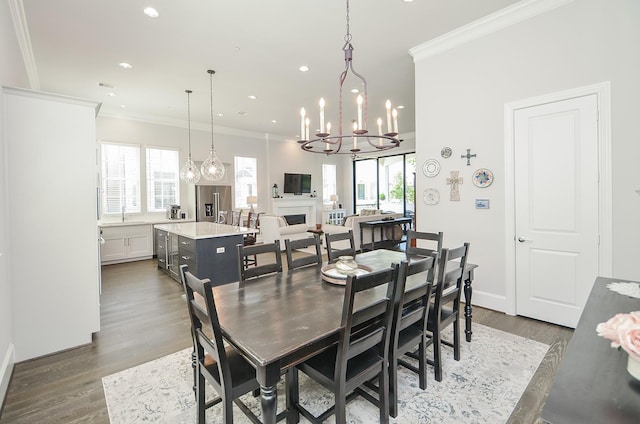 dining room with dark hardwood / wood-style flooring, an inviting chandelier, crown molding, and sink