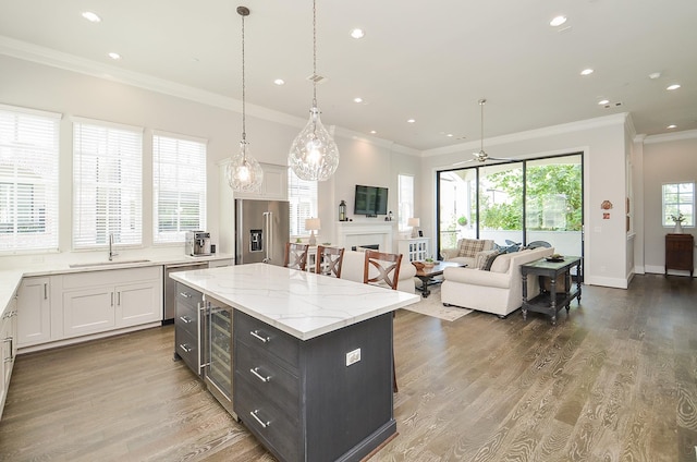 kitchen with pendant lighting, a center island, white cabinetry, and stainless steel appliances