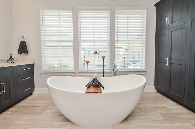 bathroom featuring vanity, tile patterned floors, and a tub