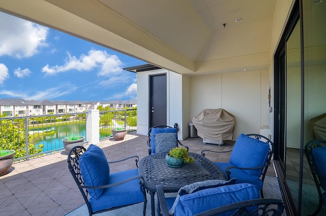 view of patio / terrace featuring a water view, a balcony, and grilling area