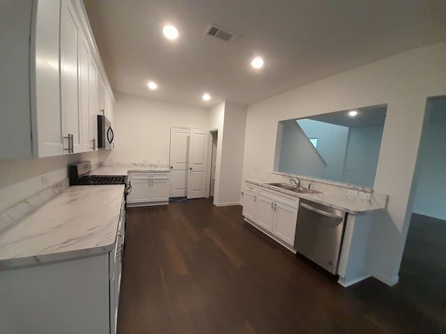 kitchen featuring white cabinets, sink, dark hardwood / wood-style floors, light stone countertops, and stainless steel appliances