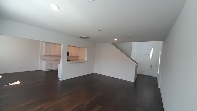 unfurnished living room with dark hardwood / wood-style flooring