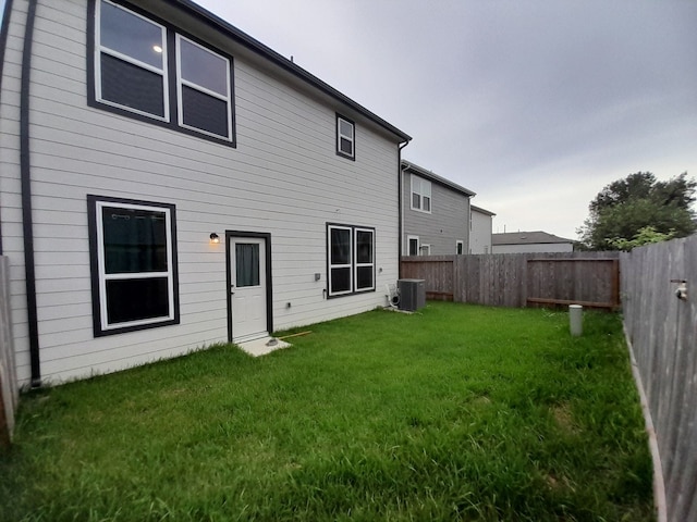 back of property featuring a yard and cooling unit