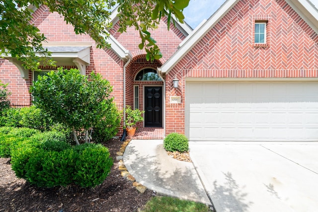 view of front of house featuring brick siding, an attached garage, and driveway
