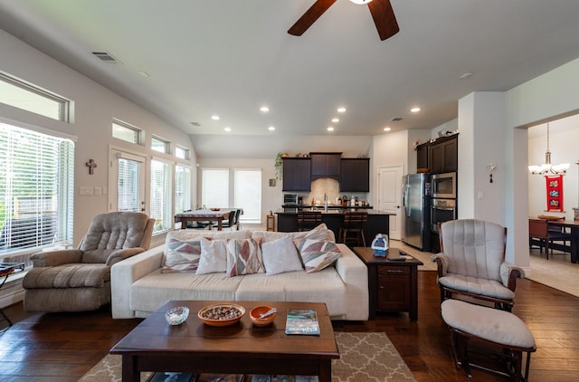 living room featuring dark hardwood / wood-style flooring, ceiling fan with notable chandelier, and sink