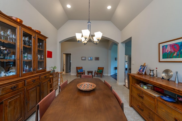 tiled dining room featuring high vaulted ceiling and an inviting chandelier