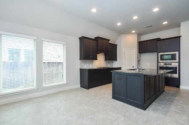 kitchen featuring tasteful backsplash, baseboards, recessed lighting, appliances with stainless steel finishes, and a sink
