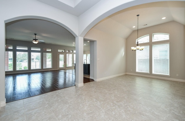 spare room with sink, ceiling fan with notable chandelier, and vaulted ceiling