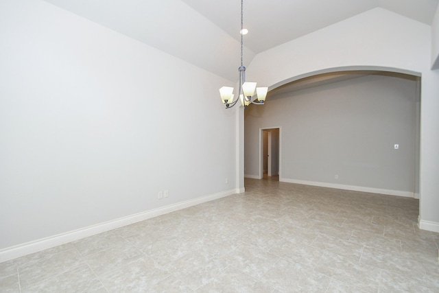 spare room featuring arched walkways, a notable chandelier, and lofted ceiling