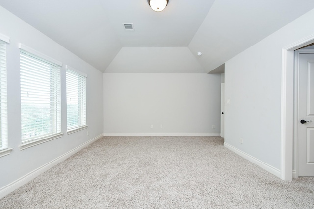 interior space featuring vaulted ceiling and light colored carpet