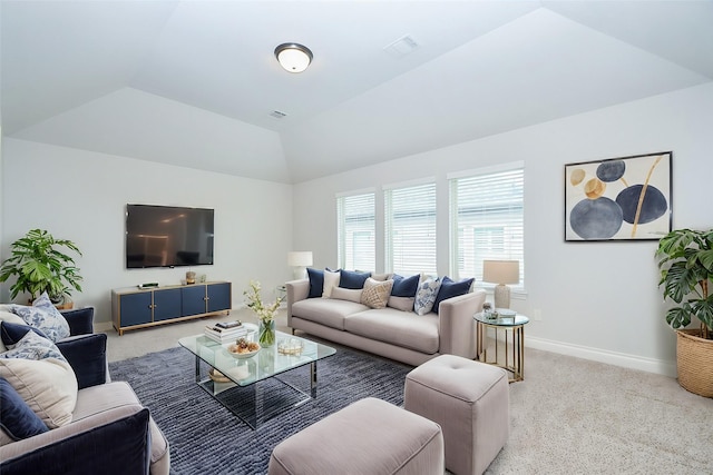 carpeted living area featuring visible vents, baseboards, and lofted ceiling