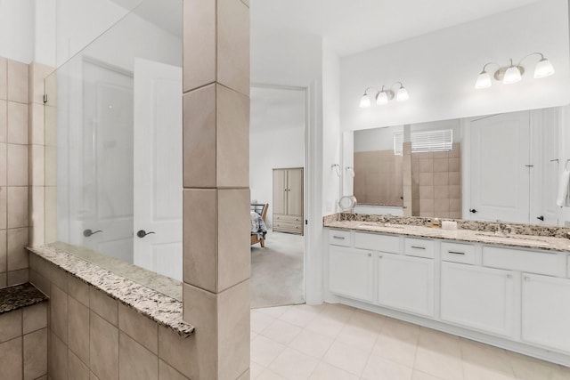 bathroom featuring tile patterned flooring, vanity, and a shower