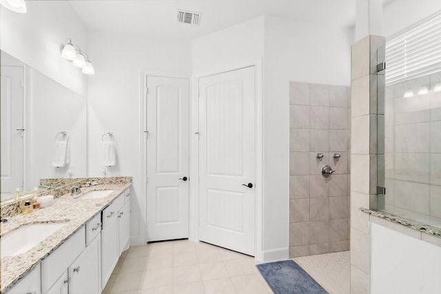 bathroom featuring tile patterned floors, vanity, and tiled shower