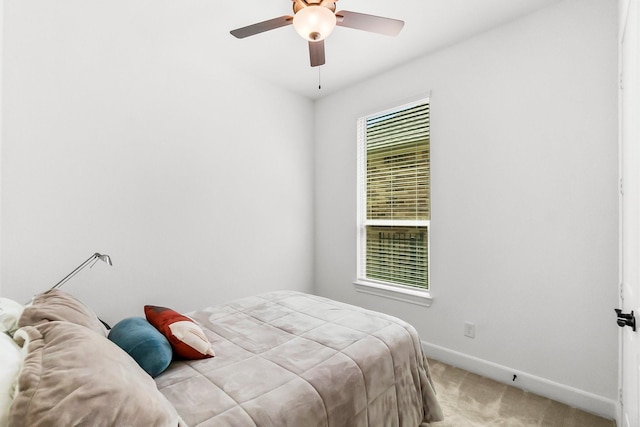 bedroom with ceiling fan, light carpet, and multiple windows