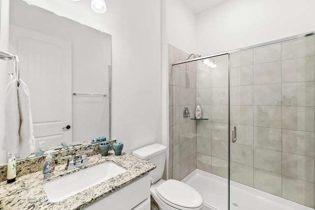 bathroom featuring vanity, toilet, and an enclosed shower