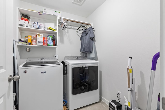 laundry area with independent washer and dryer and light tile patterned floors