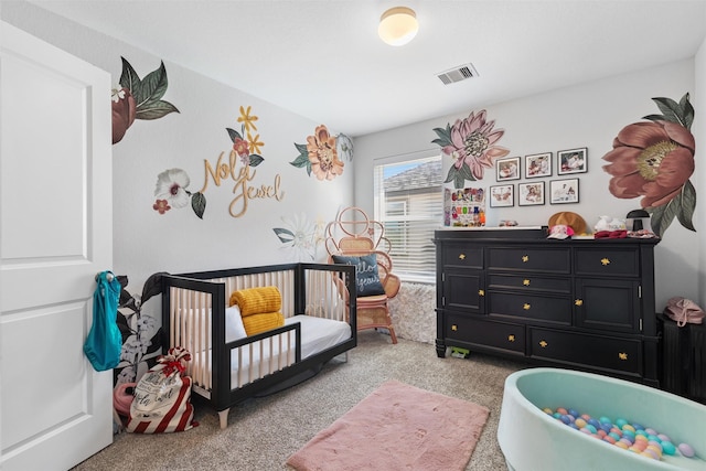 carpeted bedroom featuring a nursery area