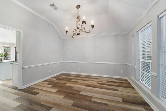 unfurnished dining area featuring hardwood / wood-style floors, vaulted ceiling, ornamental molding, and a notable chandelier